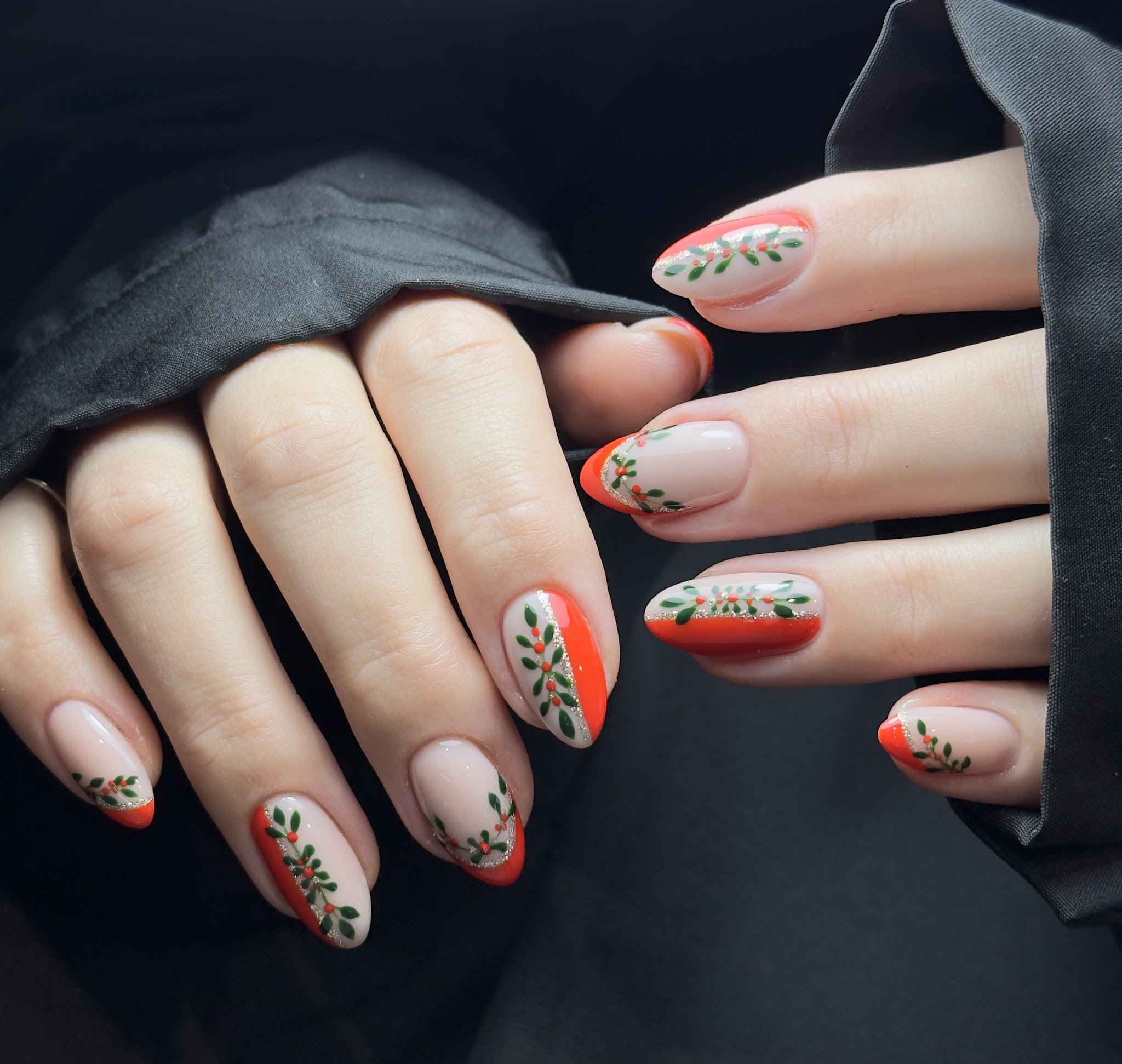 Nude almond nails with hand-painted olive branches and orange French tips