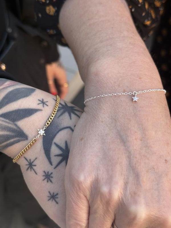 A gold chain bracelet and a silver star charm bracelet, welded on