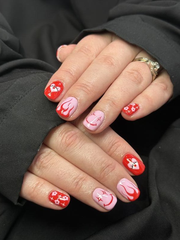Short red and pink nails with hearts, flames and smiley faces